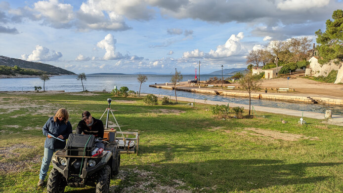 Archäolog:innen führen eine Vermessung auf der Wiese entlang des Osor-Kanals in Kroatien durch 