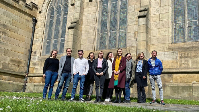 Ein Gruppe Forschender vor dem historischen Gebäude einer Universität in Großbritannien.