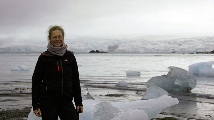 Eine junge Forscherin vor einem Meer mit Gletschereis in der Antarktis