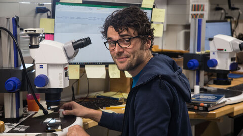 Erik Wolfgring in the lab in front of a microscope