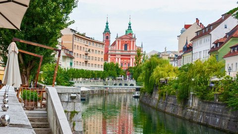 Promenade entlang eines begrünten Flussverlaufs in einer historischen Altstadt