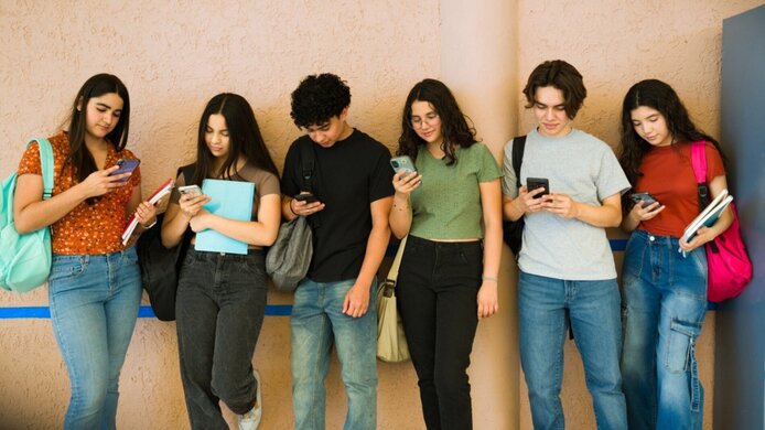 Endlos-Scrollen - sechs Jugendliche stehen in einer Reihe und sind mit ihrem Handy beschäftigt