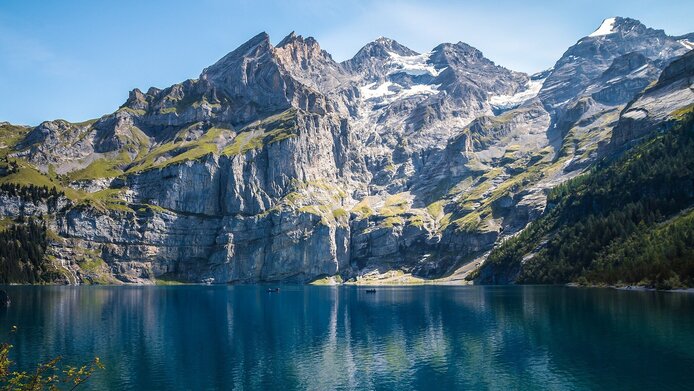 Ein großer dunkelblauer See umrahmt von Bergen