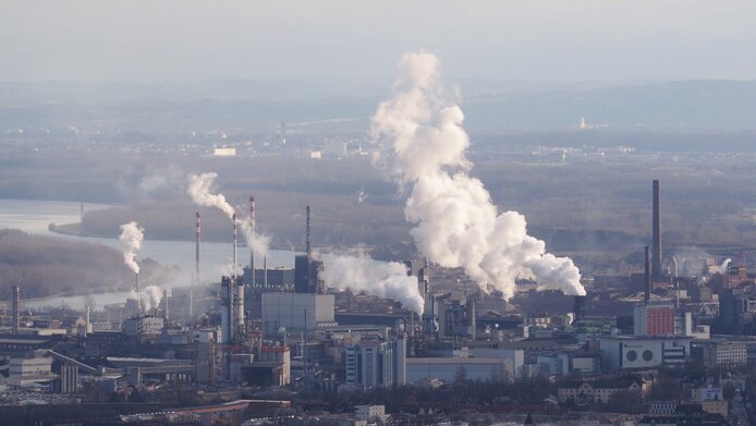 Chemiepark Linz mit rauchenden Schloten entlang der Donau