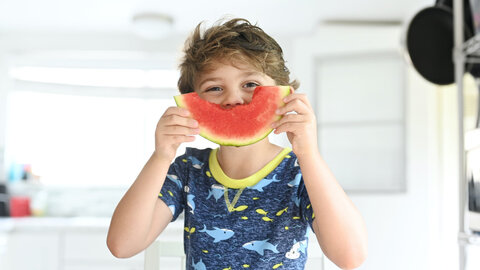 Young boy eating melon