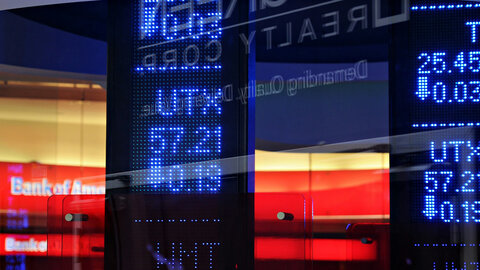 Screen with stock market prices in front of a bank
