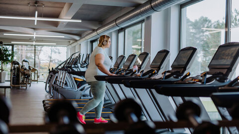 Overweight woman exercising on a stepper at the gym