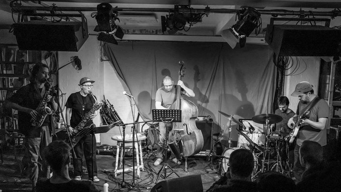 Schwarz-weiß Bild einer fünfköpfigen Free Jazz-Band bei einem Live-Auftritt