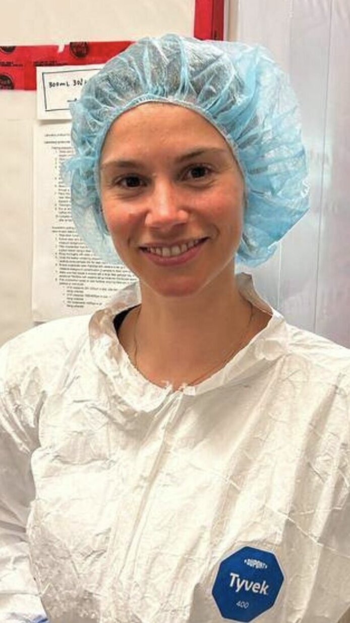 Forscherin mit Schutzkleidung in einem Reinraum