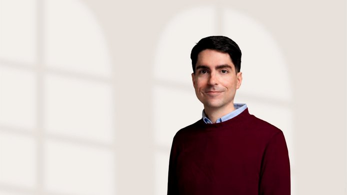 A young man with dark hair and jumper in bordeaux-red