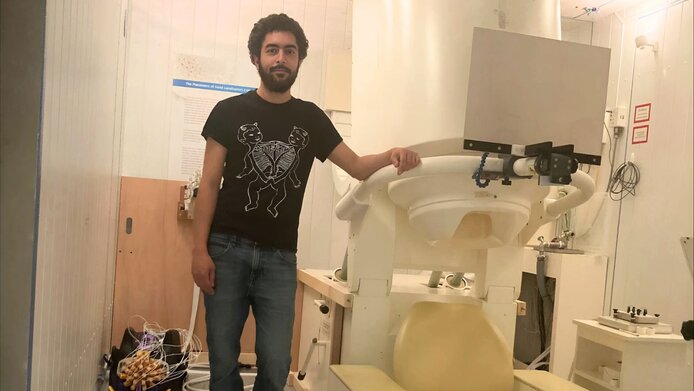 Young researcher standing next to a neuroimaging device in a laboratory 
