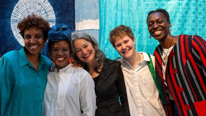 Fünf weibliche Mitarbeiterinnen eines künstlerischen Forschungsprojekt vor einem Ausstellungsstück