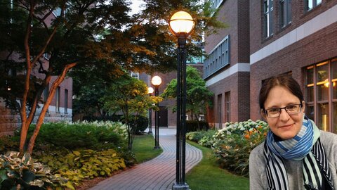 Researcher with old brick buildings of St. George Campus Toronto in the background