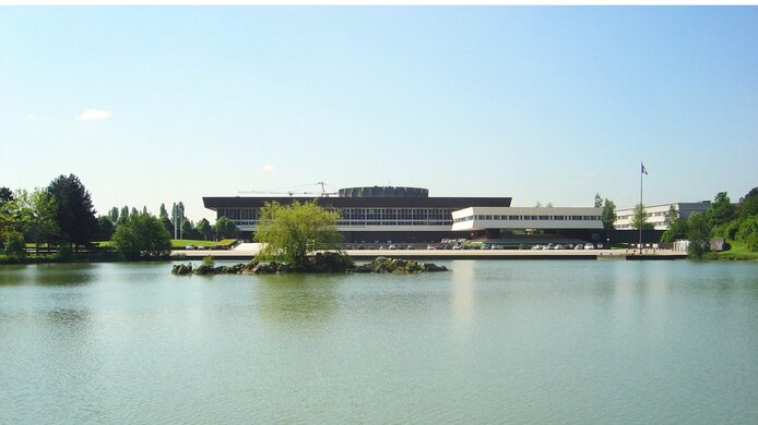 Großes Forschungsgebäude vor einem See 