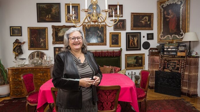 Bibelwissenschaftlerin Irmtraud Fischer in ihrer Wohnung in Graz. Im Hintergrund mit zahlreichen Kunstwerken, die biblische Szenen zeigen.
