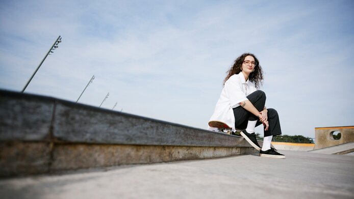 Three young men are sitting on a stone staircase in the park 