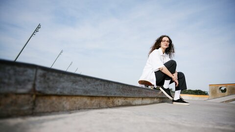Three young men are sitting on a stone staircase in the park 