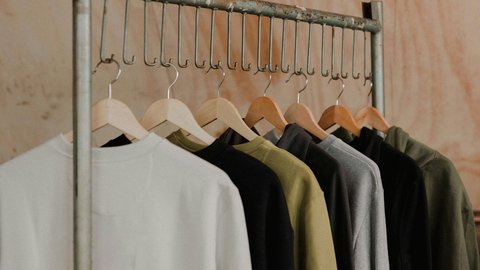 Sweatshirts auf Kleiderbügeln hängen an einer Metallstange in einem Shop