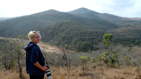 Researcher Bea Maas in front of wilderness and mountains in Africa